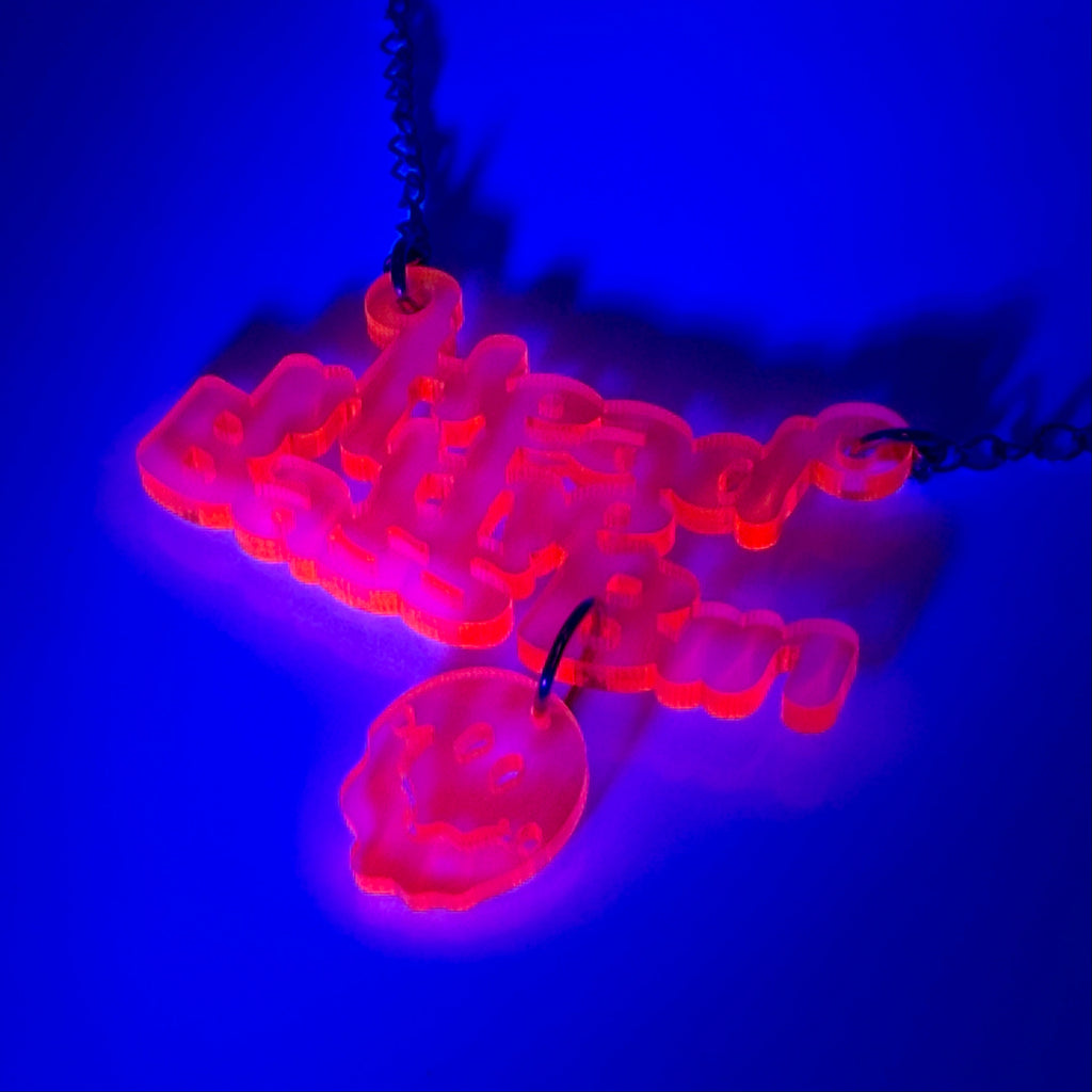 A glowing neon-style pendant necklace in bright pink and orange, suspended from a black chain against a deep blue background.